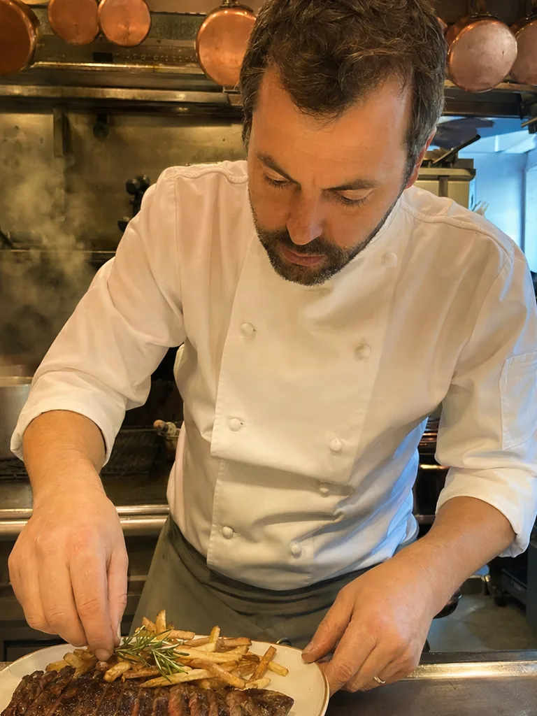 Banquetas, mantel blanco y cocina abierta